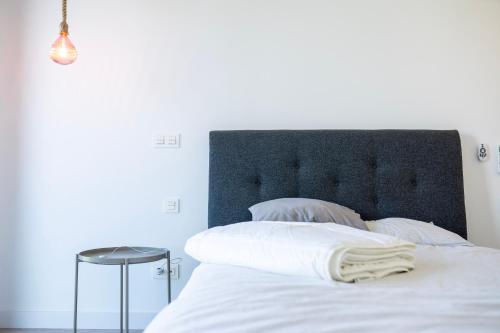 a white bed with a black headboard and a table at Casa de Nero - Premium House with Jacuzzi Next to Golf Course in Caleta De Velez