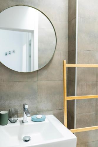 a bathroom with a white sink and a mirror at Casa de Nero - Premium House with Jacuzzi Next to Golf Course in Caleta De Velez