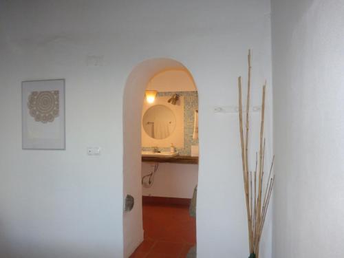 a white hallway with a sink and a mirror at Solar da Cumeada in Reguengos de Monsaraz
