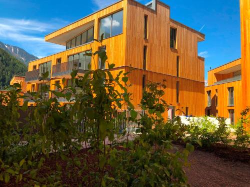 a wooden building with a lot of windows at All-Suite Resort Ötztal in Oetz