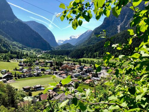a village in a valley with mountains in the background at All-Suite Resort Ötztal in Oetz