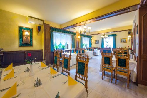um restaurante com mesas e cadeiras num quarto em Kikelet Club Hotel em Miskolctapolca