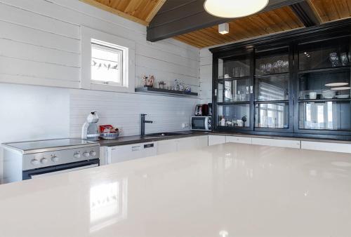 a kitchen with white appliances and black cabinets at Blue Viking Luxury Cabin in Selfoss