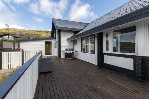 a house with a wooden deck in front of it at Blue Viking Luxury Cabin in Selfoss