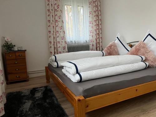 una camera con un letto con cuscini sopra di Pension Hirsch a Fluorn