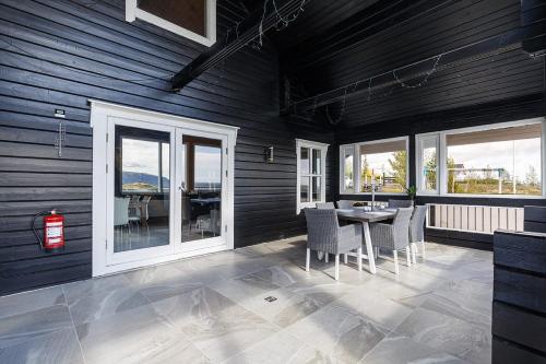 a dining room with a table and chairs and windows at Blue Viking Luxury Cabin in Selfoss