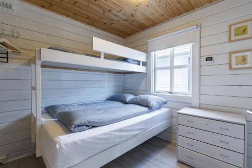 a small bedroom with a bunk bed and a window at Blue Viking Luxury Cabin in Selfoss