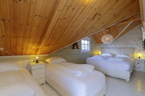 two beds in a room with wooden ceilings at Blue Viking Luxury Cabin in Selfoss