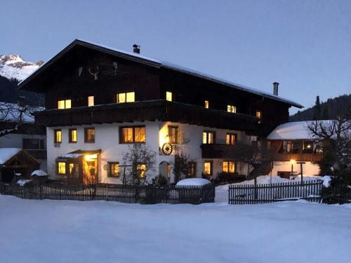 ein großes Haus mit Licht im Schnee in der Unterkunft Bergheimat - Olga Geiger in Bach