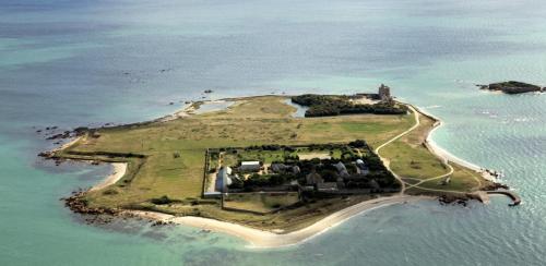 an island in the ocean with a castle on it at Chez MARLENE in Quettehou