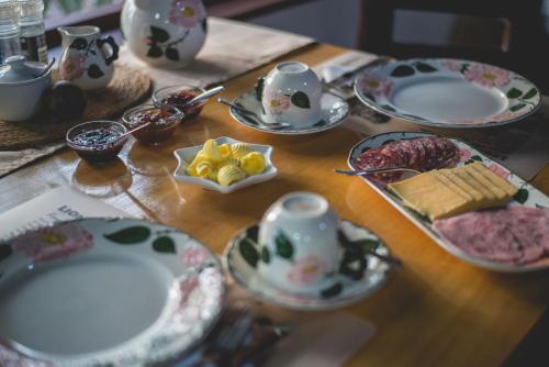 a wooden table with plates and cups and dishes on it at Thokozani Lodge in White River