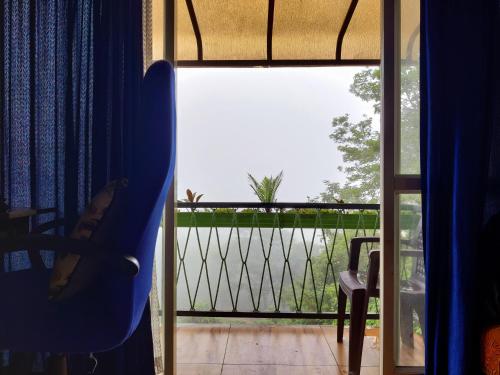 an open door to a balcony with a view at Raymond's Holiday Homes in Vythiri