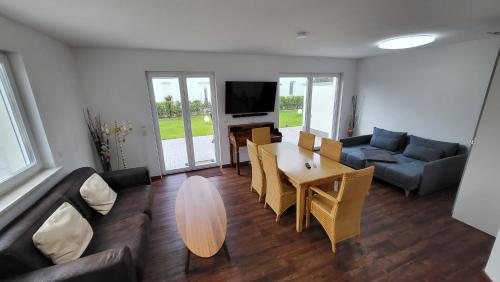 a living room with a table and a couch at Ferienwohnungen Im Grund 22, 22a, 22c Birkenstein in Hoppegarten