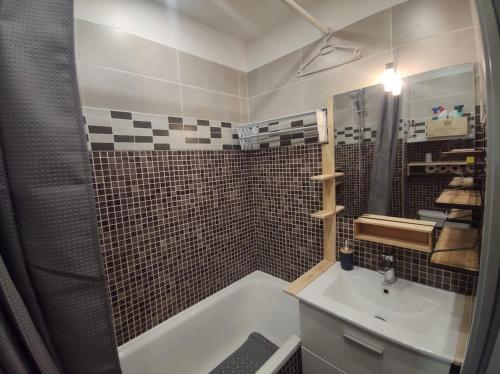 a bathroom with a tub and a sink and a shower at studio Loubat pyrénée, ménage inclus in Arette