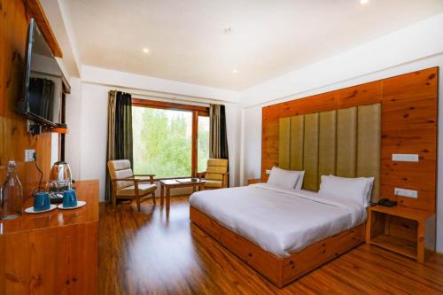 a bedroom with a bed and a desk and a television at Sky Desert in Leh