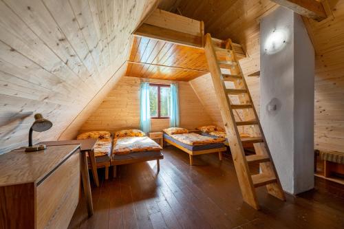pokój z 2 łóżkami i schodami w kabinie w obiekcie Chatový tábor Malý Ratmírov w mieście Malý Ratmírov