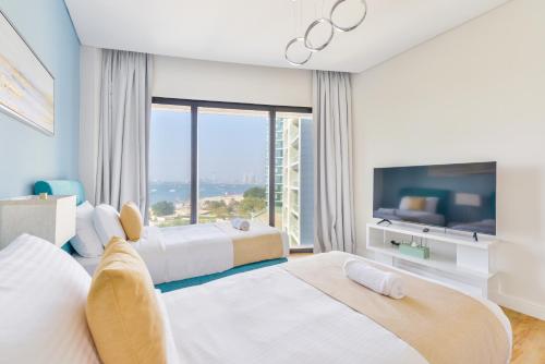 Habitación de hotel con 2 camas y ventana grande. en Address Beach Residences, en Dubái