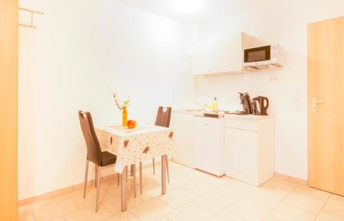 een keuken met een tafel en stoelen bij Haus Emona - Ihre Pension in Freiburg in Freiburg im Breisgau