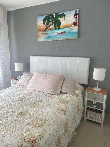 1 dormitorio con 1 cama blanca, 2 mesitas de noche y 2 lámparas en Antibes, en Punta del Este