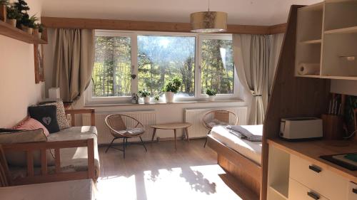 een woonkamer met 2 ramen en een tafel en stoelen bij Karwendel-Lodge in Scharnitz
