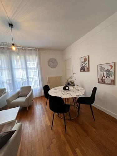 un salon avec une table, des chaises et un canapé dans l'établissement Le beau Milo 2 chambres Coeur de ville avec Balcon Netflix, au Creusot