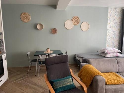 ein Wohnzimmer mit einem Sofa und einem Tisch in der Unterkunft F2 Rez de Chaussée Ô meublé de Pithiviers in Pithiviers