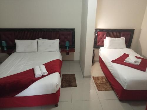 two beds in a hotel room with towels on them at Emampingeni lodge in Bizana