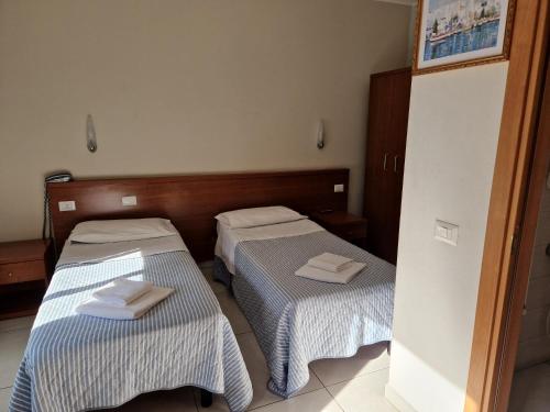 two beds in a hotel room with towels on them at Hotel Bonola in Milan