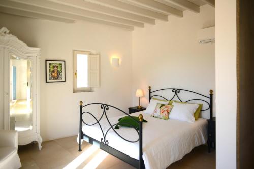 a bedroom with a black bed in a white room at Casa Mimi in Gérgal