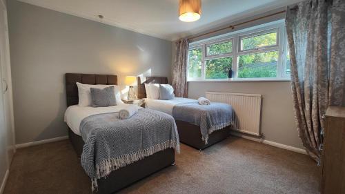 a bedroom with two beds and a window at Piping Green 5 bedroom House in Winchester