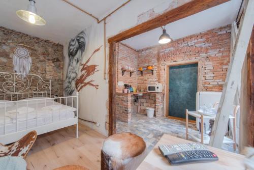 een slaapkamer met bakstenen muren, een bed en een bureau bij Accommodation at the Zeus Apartment in Bratislava