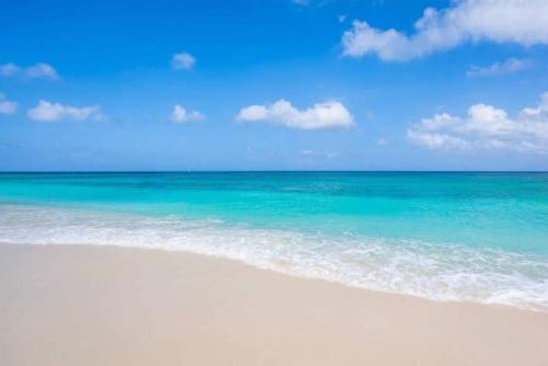 una playa con el océano y un cielo azul en Beach Living at Island Pine Villas BLSE, en George Town