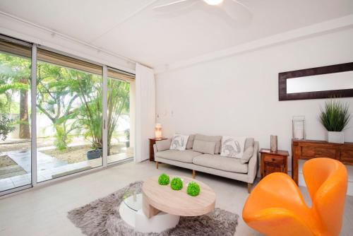 uma sala de estar com um sofá e uma mesa em Beach Living at Island Pine Villas BLSE em George Town