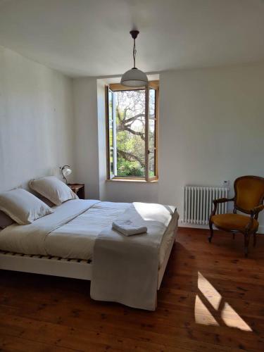 une chambre avec un lit, une fenêtre et une chaise dans l'établissement Château de Parançay - 15 people lodge, à Bernay