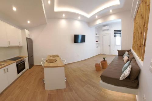 een grote woonkamer met een bank en een keuken bij Deja vu Ευχάριστο σπίτι στο κέντρο του νησιού ΊΟΥ in Ios Chora