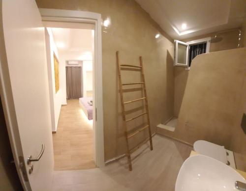uma casa de banho com um WC e um quarto com uma escada em Deja vu Ευχάριστο σπίτι στο κέντρο του νησιού ΊΟΥ em Chora, Ios