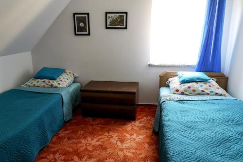 een slaapkamer met 2 bedden, een tafel en een raam bij Ranczo Spełnionych Marzeń in Sosnówka