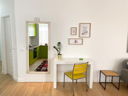 a dining room with a table and a mirror at Metro Suites in Tirana