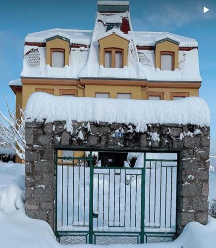 a building with a gate in the snow at Charming Vosges Loft - Family-Owned Mountain Haven in Le Hohwald