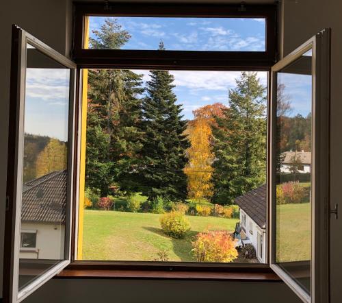 an open window with a view of a yard at Charming Vosges Loft - Family-Owned Mountain Haven in Le Hohwald
