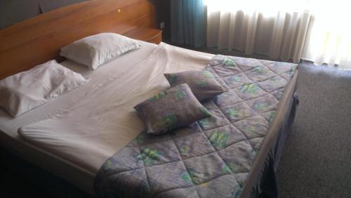 a bed with white sheets and pillows on it at Family Hotel Lazuren Briag in Burgas City