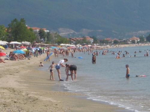 a group of people on the beach at a beach at Armiriki Rooms in Vrasná