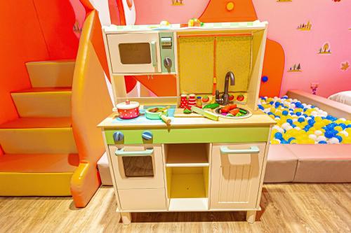 a play kitchen with a sink and a surfboard at 童玩樂親子旅宿Toy Fun Hotel in Luodong
