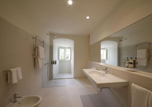 a bathroom with two sinks and a large mirror at Montebelo Mosteiro de Alcobaça Historic Hotel in Alcobaça