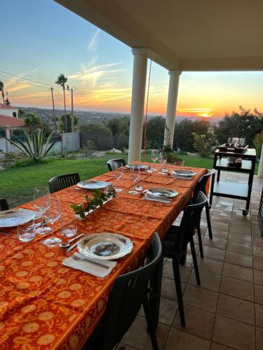uma longa mesa com copos de vinho em cima de um pátio em Villa Tranberg Suites nas Ferreiras