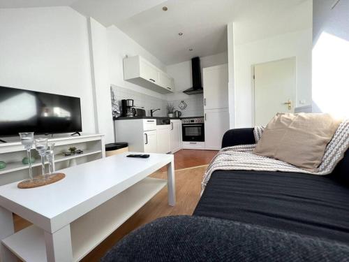 Sala de estar blanca con sofá y mesa en R&L Apartment Wettiner Strasse, en Leipzig
