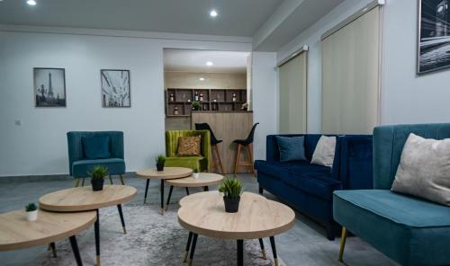 a living room with blue couches and tables at Quest Boutique Hotel in Gwarinpa