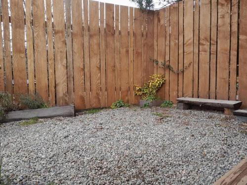 a wooden fence with a bench and a wooden fence at Calida Mini Casa in San Carlos de Bariloche