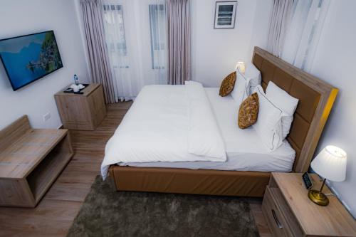 a bedroom with a large bed with white sheets and pillows at Quest Boutique Hotel in Gwarinpa