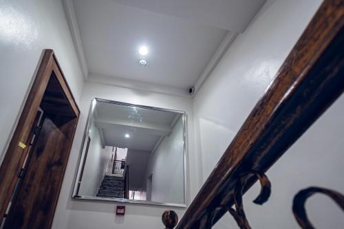 a hallway with a mirror and a stairway at Quest Boutique Hotel in Gwarinpa